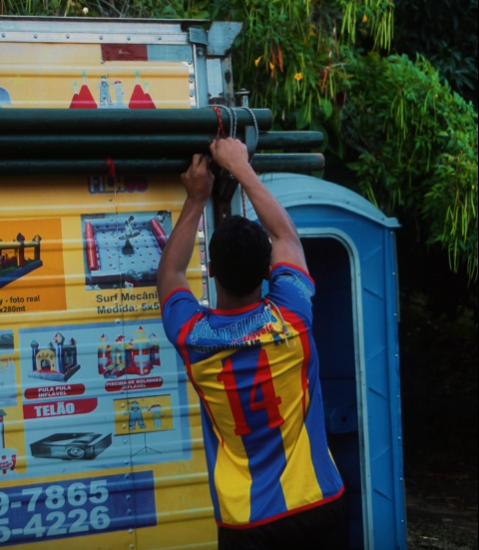 Integrante da equipe prendendo os postes no caminhão