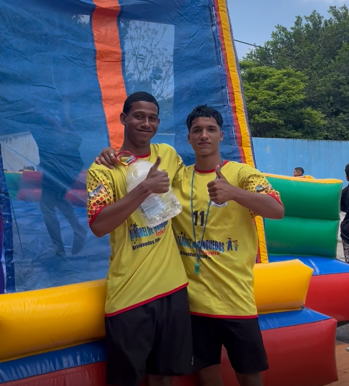 Dois integrantes da equipe ao lado do brinquedo inflável